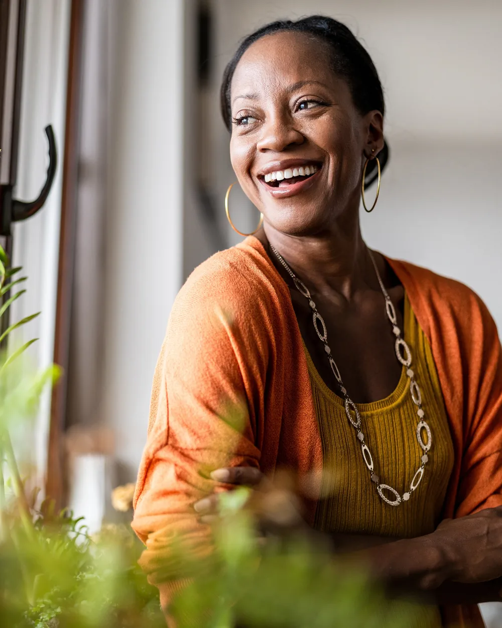 Smiling woman in an orange top at home