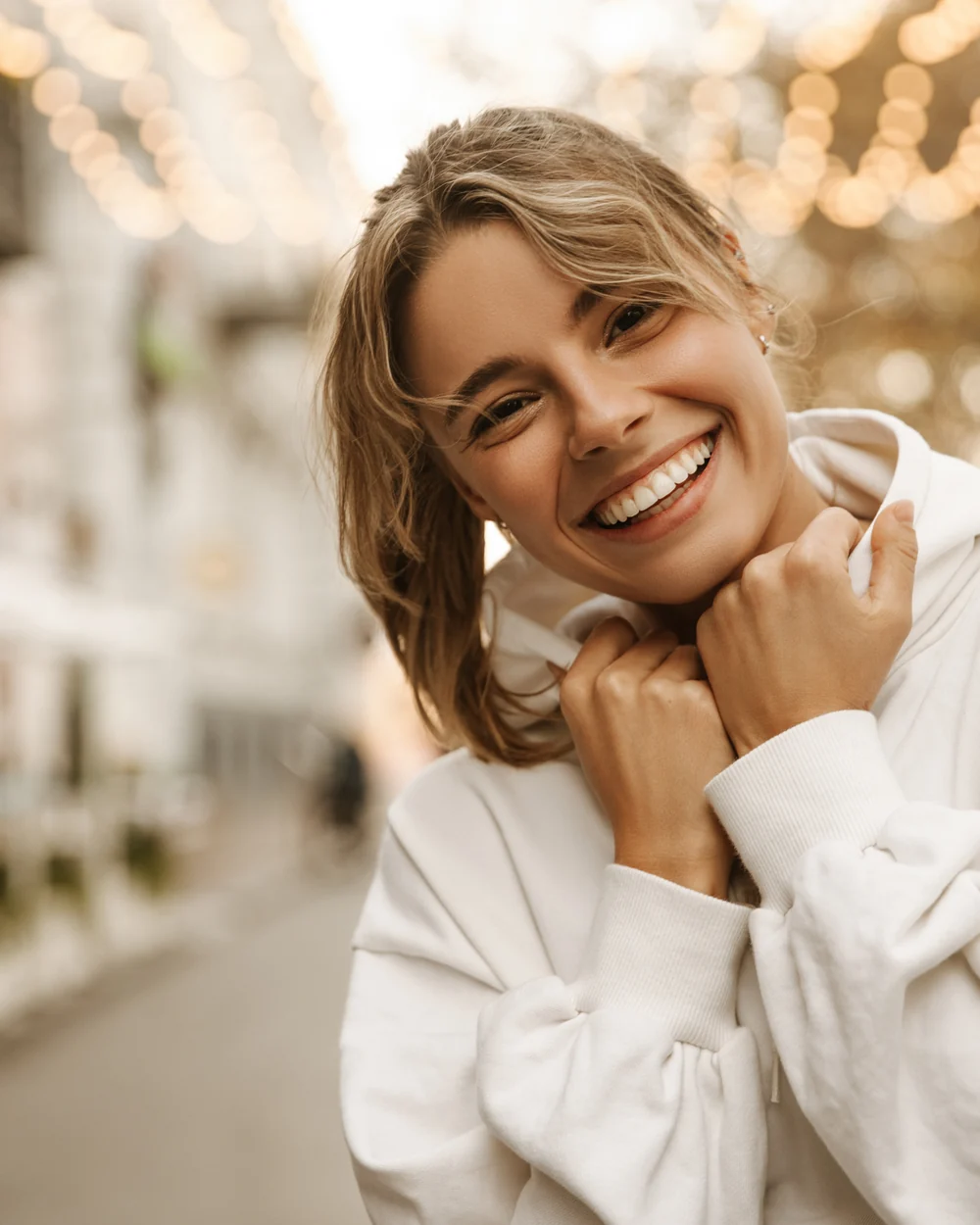 Smiling woman in a white sweater outdoors