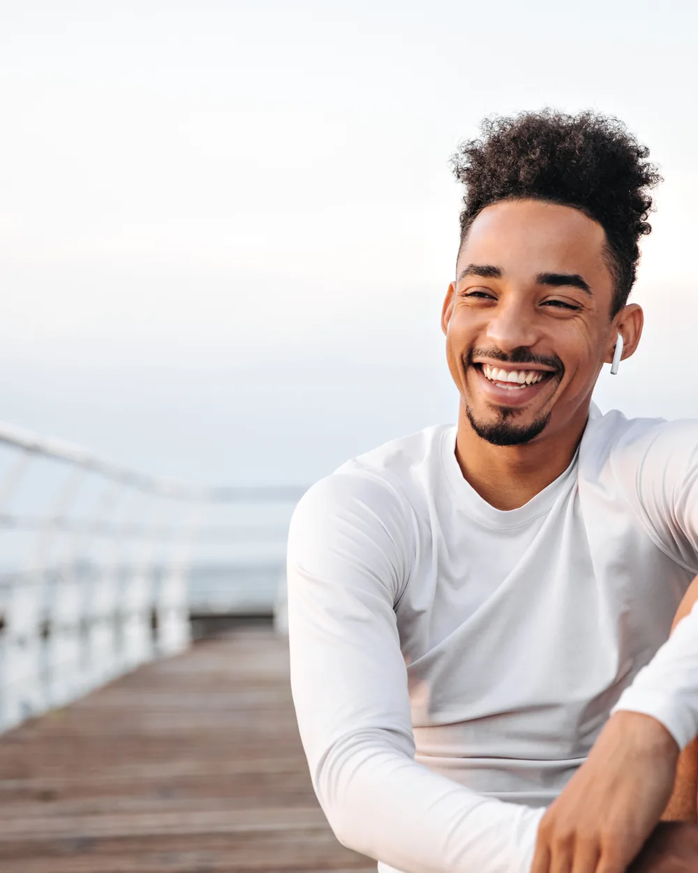 Smiling adult man seated outdoors