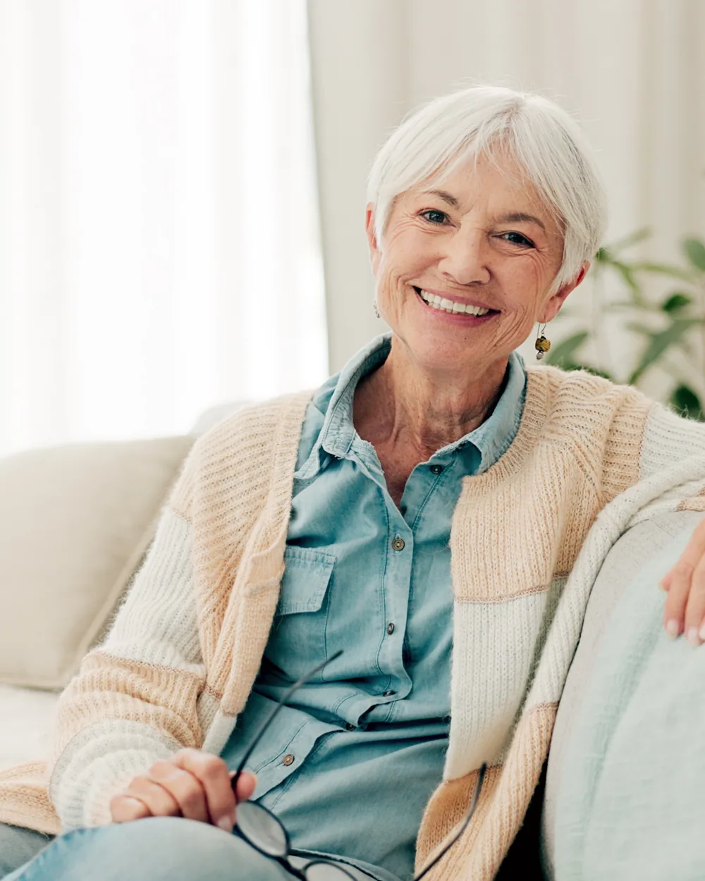 Smiling older woman seated on a sofa