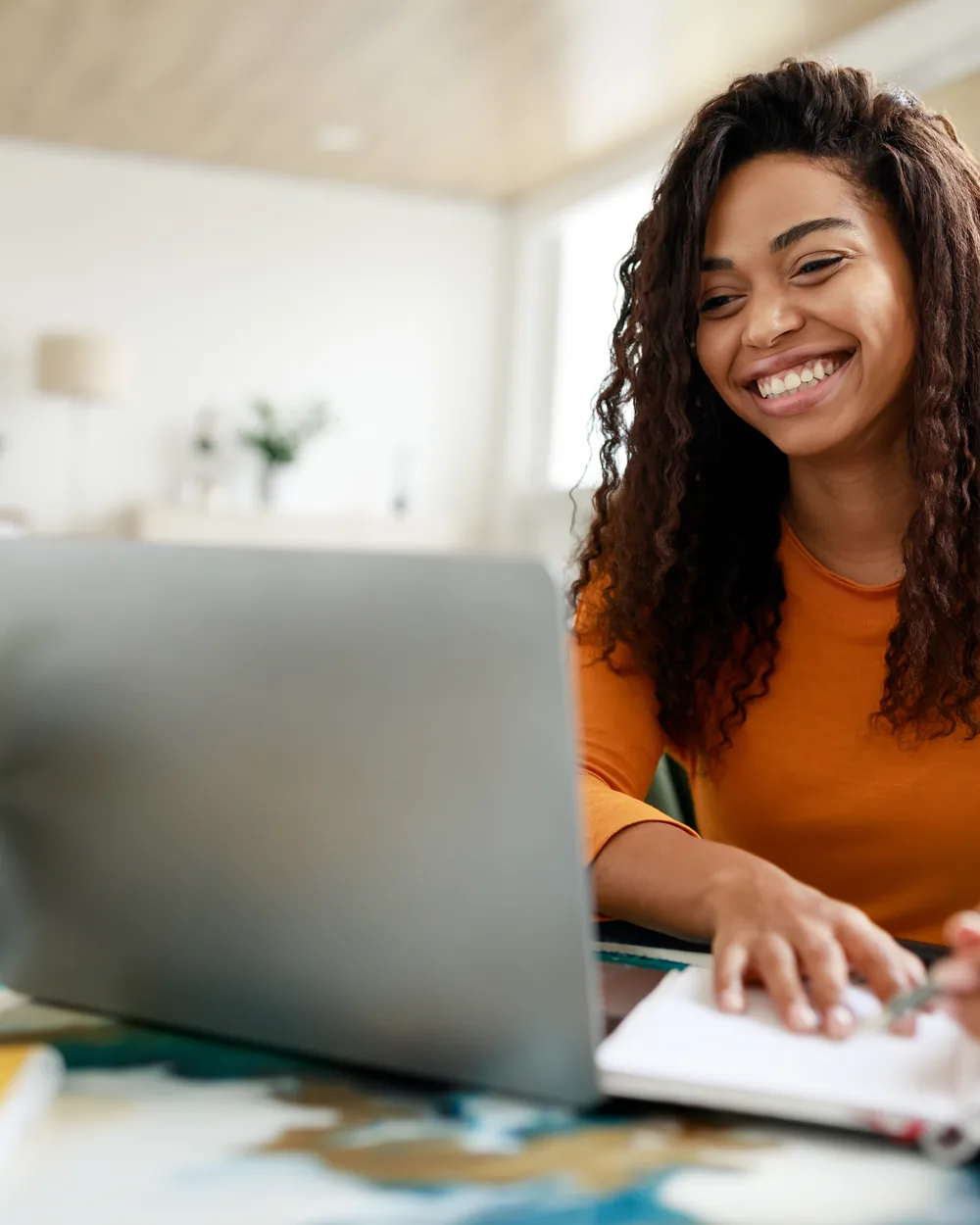 Smiling woman in a yellow sweater at a desk