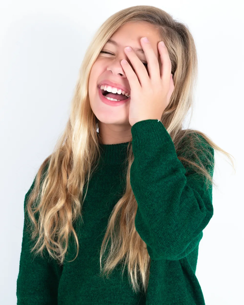 Smiling teen covering one eye with her hand