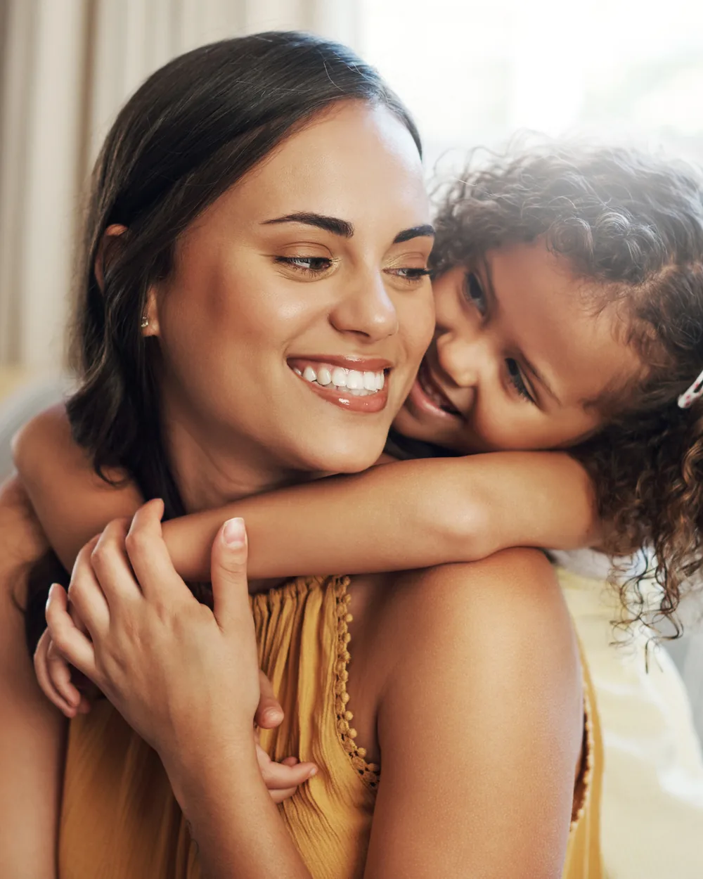 Smiling parent hugging a child at home