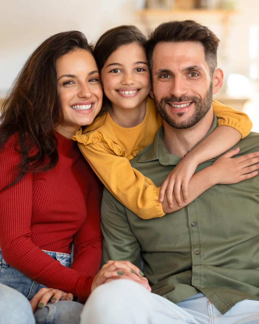 Smiling family seated together in a bright home setting