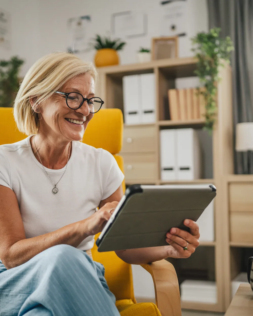 Relaxed older woman reading on a tablet at home