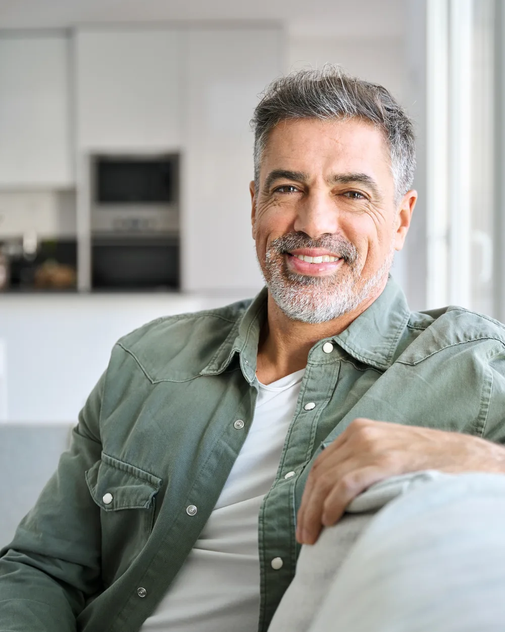 Smiling adult man seated in a bright home setting