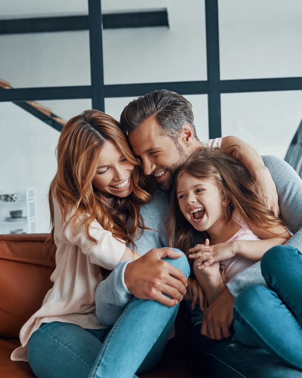 Family laughing together on a couch