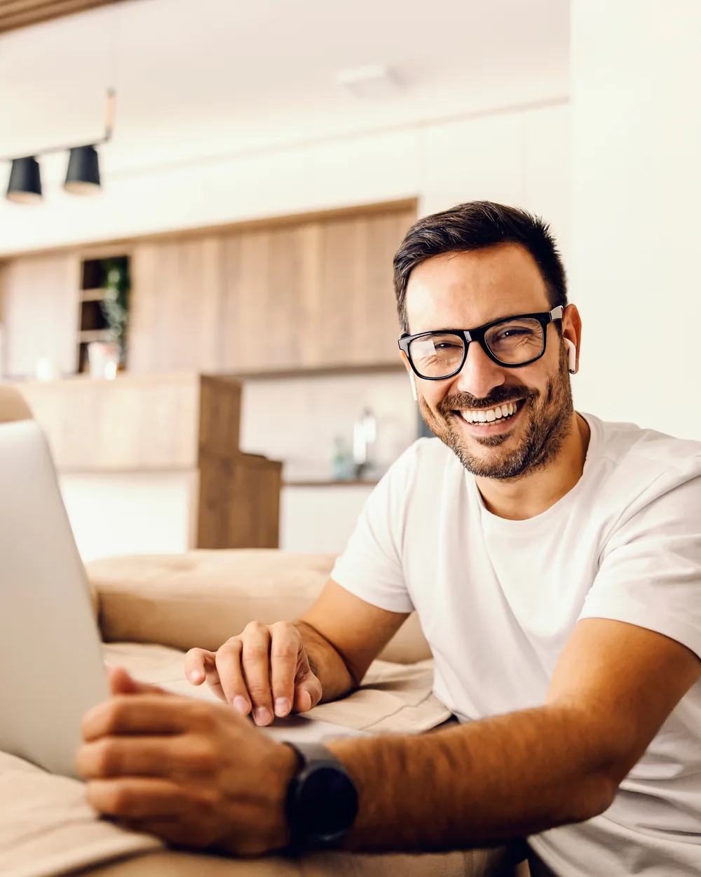 Smiling man using a laptop at home
