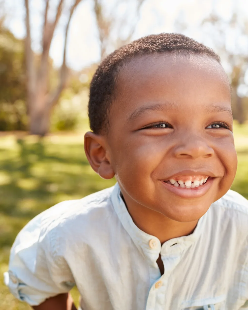 Smiling boy outdoors in a white shirt