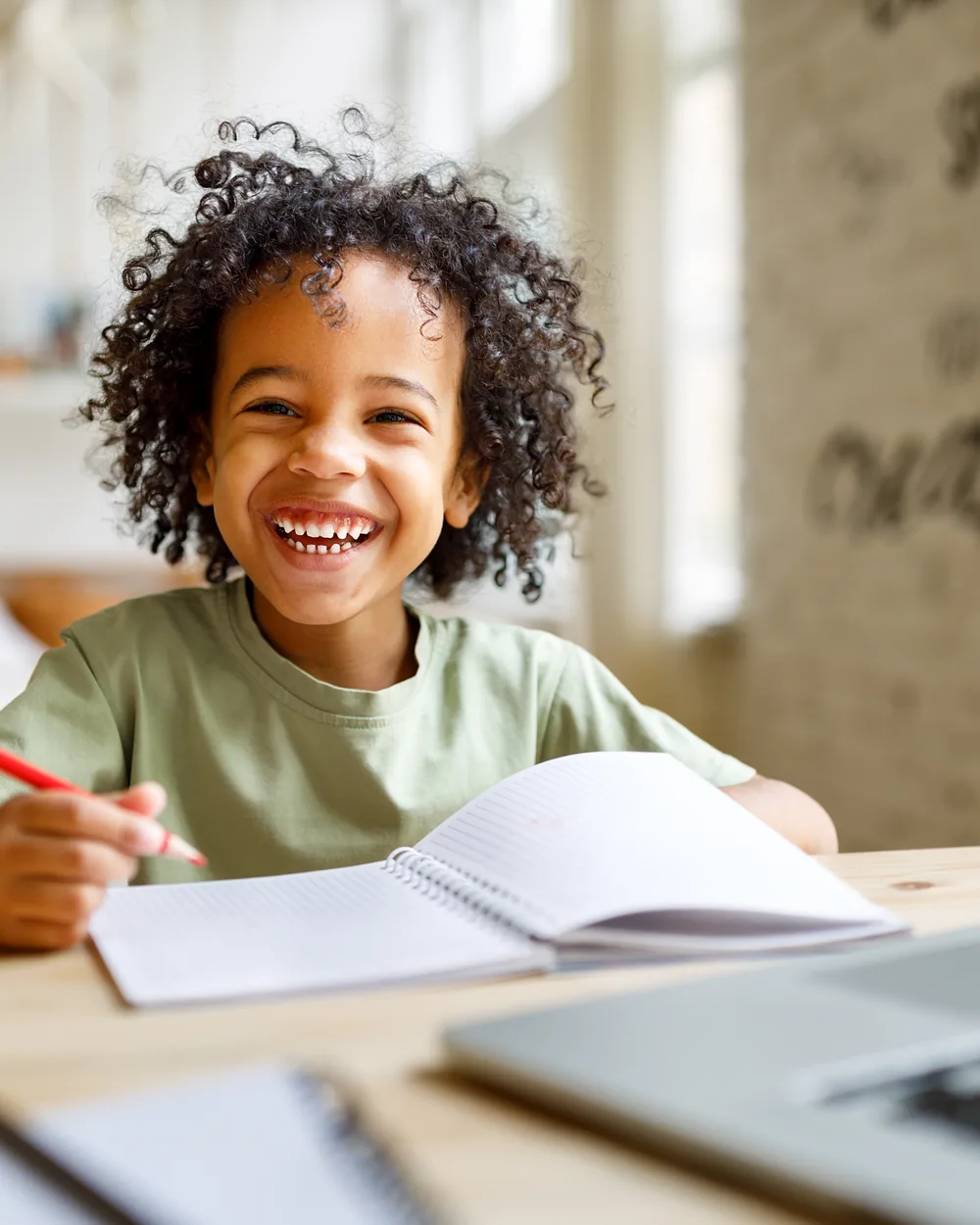 Smiling child writing at a desk
