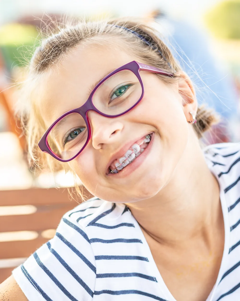 Smiling girl with braces outdoors