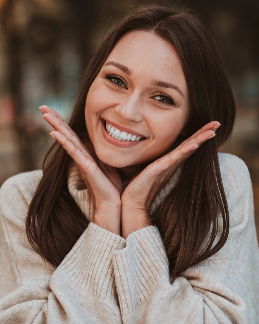 Smiling woman resting her hands near her face
