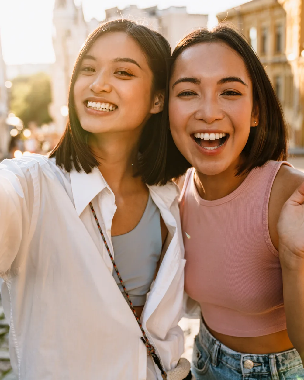 Two young adults smiling together outdoors